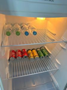 an open refrigerator filled with drinks and soda cans at Vila do Chave Dona Florinda 14 in Itajaí