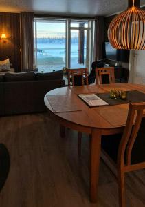 a living room with a wooden table and a couch at Flat With Lake View In Sjusjøen in Sjusjøen +15 photos