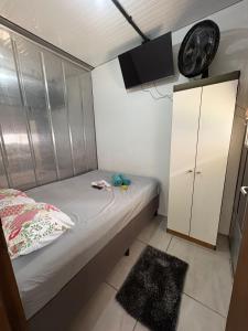 a small bedroom with a bed and a cabinet at Vila do Chave Dona Florinda 14 in Itajaí