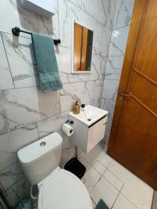 a white bathroom with a toilet and a sink at Vila do Chave Dona Florinda 14 in Itajaí +12 photos