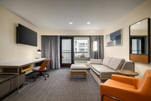 a living room with a couch and a desk at Courtyard Fargo Moorhead, MN in Moorhead