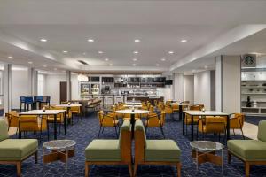 a restaurant with tables and chairs and a kitchen at Courtyard Fargo Moorhead, MN in Moorhead