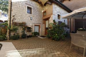 a stone building with a patio with chairs and plants at Tenuta Maraveja 1462 in Brendola