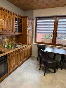 a kitchen with wooden cabinets and a table and chairs at WG-Zimmer-Monteurzimmer-Ferienwohnung bis 10 Personen in Aldenhoven