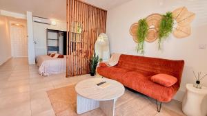 a living room with a red couch and a table at Maemora - Studio in Les Trois-Îlets