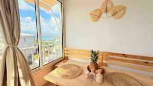 a dining room with a table and a large window at Maemora - Studio in Les Trois-Îlets
