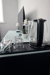 a black counter with glasses and a coffee maker on it at The Dene Homestay in Drogheda