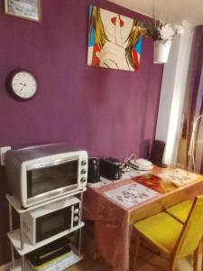 a kitchen with a table with a microwave and a clock at Graeff luxury Apartment in Cologne