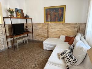 a living room with a white couch and a television at Elportal in Alta Gracia