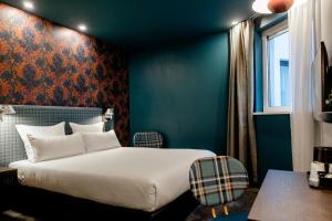 a bedroom with a white bed and a blue wall at Motel One Edinburgh-Princes in Edinburgh