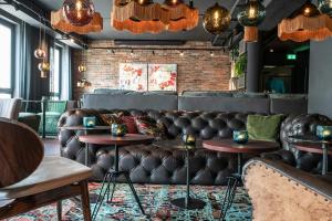 a bar with a leather couch and two tables at Motel One Berlin-Mitte in Berlin