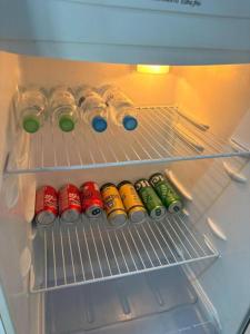 a refrigerator filled with bottles and cans of soda at Vila do Chaves Casa da Popis 23 in Itajaí