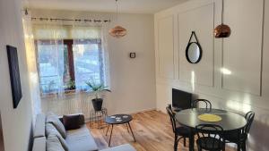 a living room with a table and a couch at Pelican - Czarny Dwór A in Zaspa