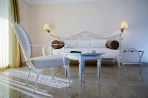 a living room with a couch and a table and chairs at Hotel Azimut in Sveti Stefan