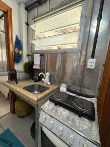 a kitchen with a stove and a sink at Vila do Chaves Bruxa do 71 in Itajaí +9 photos