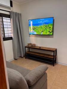 a living room with a flat screen tv on the wall at Departamentos Boutique Misiones in Puerto Iguazú