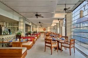 a restaurant with wooden tables and chairs and windows at Weligama Bay Marriott Resort & Spa in Weligama