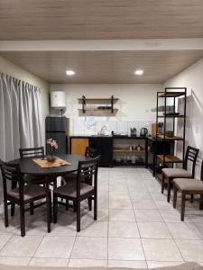 a dining room with a table and chairs and a kitchen at Departamentos Boutique Misiones in Puerto Iguazú