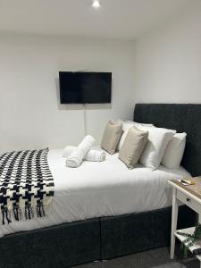 a bedroom with a large bed with a tv on the wall at Studio 2 - Eign St Hereford in Hereford