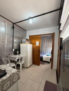 a kitchen with a refrigerator and a table and chairs at Vila do Chaves Casa Seu Madruga 72 in Itajaí