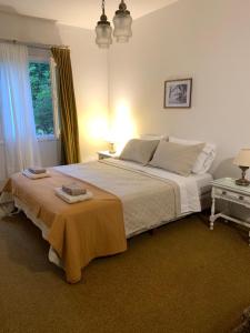 a bedroom with a large white bed with two towels on it at Chacra Los Cipreses - Casa completa con gran parque arbolado, 6 personas, entorno tranquilo in Cinco Saltos
