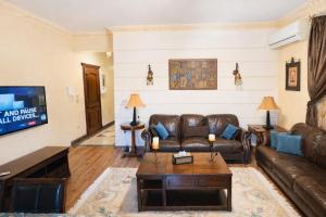 a living room with a couch and a tv at The New Cairo 3BR Residence in Cairo