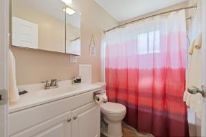 a bathroom with a toilet and a red shower curtain at Akron 2 Bed 1 Bath Mountain Oasis Dog Friendly in Akron +23 photos