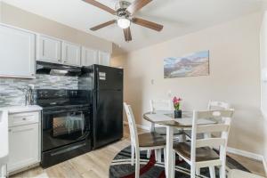 a kitchen with a black refrigerator and a table with chairs at Akron 2 Bed 1 Bath Mountain Oasis Dog Friendly in Akron