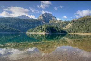 a reflection of a mountain in a body of water at Vila Mia in Žabljak