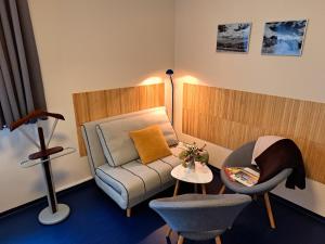 a living room with a couch and a chair at Apartmány Hutisko 769 in Hutisko
