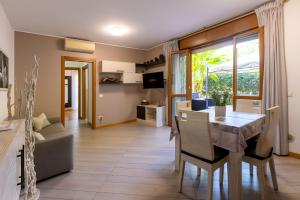 a living room with a table and chairs and a dining room at HOUSE GARDEN MILANO -Pet Friendly, Giardino Chiuso in Trezzano sul Naviglio