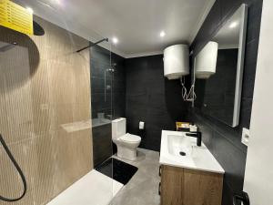a bathroom with a toilet and a sink and a shower at Villa Torrevieja in Torrevieja