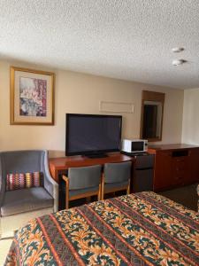 a hotel room with a bed and a desk with a television at Federal Way Motel in Federal Way