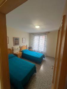 a bedroom with two blue beds and a window at Apartamento Pedro de Cella in Cella