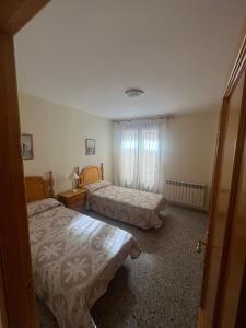 a bedroom with two beds and a window at Apartamento Pedro de Cella in Cella