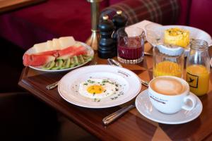 a table topped with plates of food and a cup of coffee at 1904 Benfica Hotel FLH Hotels in Lisbon