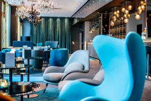 a restaurant with blue chairs and a bar at Motel One Berlin-Ku'Damm in Berlin