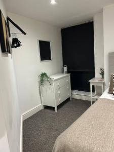 a bedroom with a bed and a dresser and a window at Studio 3 - Eign St Hereford in Hereford