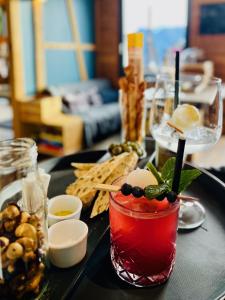 a table with a drink on a tray with snacks at Berggasthaus Eggberge - Boutique Mountain Hotel - Access via Cablecar in Altdorf