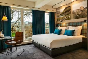 a hotel room with a large bed and a window at Motel One Edinburgh-Royal in Edinburgh