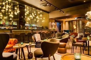 a restaurant with chairs and tables and a bar at Motel One Edinburgh-Royal in Edinburgh