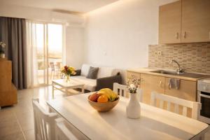 a kitchen and living room with a bowl of fruit on a table at Casa al' Tati Apartments in Ialysos
