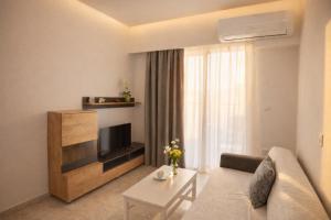 a living room with a couch and a television at Casa al' Tati Apartments in Ialysos