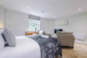 a bedroom with a large white bed and chairs at Rock Mill - Stunning Studio Apartment in Stony Middleton