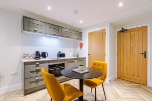 a kitchen with a table and yellow chairs in a room at Rock Mill - Stunning Studio Apartment in Stony Middleton +36 photos