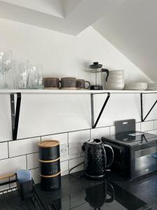 a kitchen with a counter with a microwave and dishes at Studio 5 - Eign St Hereford in Hereford +5 photos
