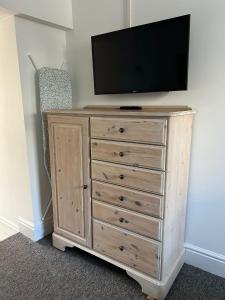 a wooden dresser with a television on top of it at Studio 5 - Eign St Hereford in Hereford