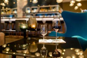 two glasses of wine sitting on a table at Motel One Frankfurt-Airport in Frankfurt +26 photos