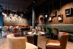 a restaurant with tables and chairs and a bar at Motel One Frankfurt-East Side in Frankfurt +19 photos