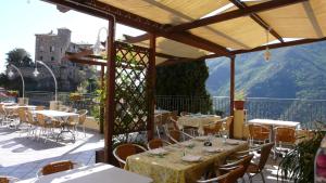a patio with tables and chairs on a balcony at Albergo Cecchin in Balestrino